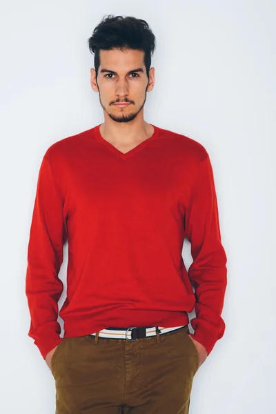 Young handsome man in red sweater and brown trousers — Stock Photo, Image