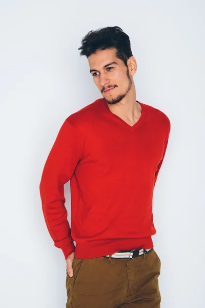 Young handsome man in red sweater and brown trousers — Stock Photo, Image