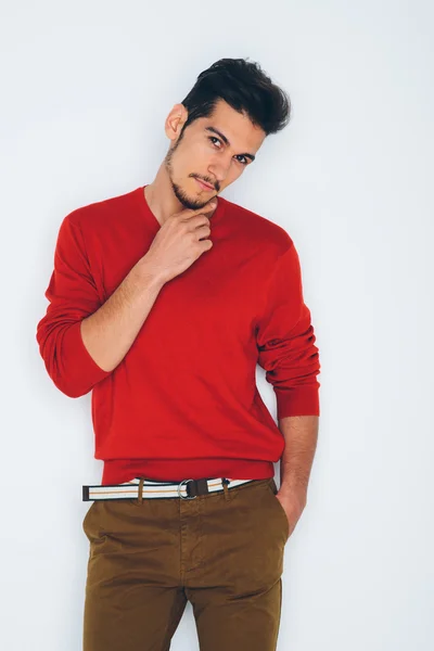 年轻英俊的男人，穿着红毛衣和咖啡色长裤 — 图库照片