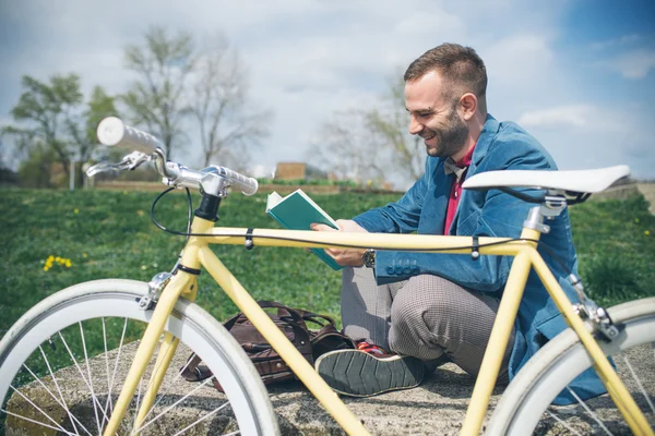 Jonge knappe man met fiets tijd buitenshuis doorbrengen — Stockfoto