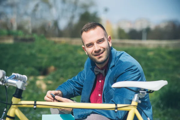 Jonge knappe man met fiets tijd buitenshuis doorbrengen — Stockfoto