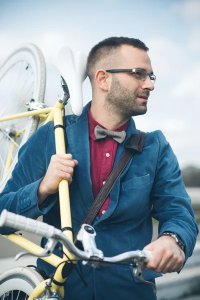 Young handsome man with bicycle spending time outdoors