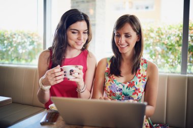 Bir kafede gülümseyen, dedikodu, kahve içme iki kız