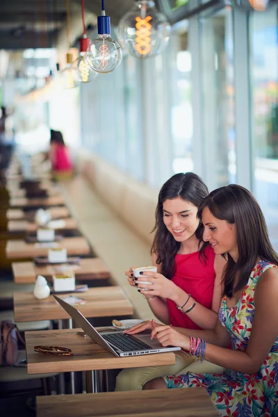 Duas meninas em um café, sorrindo, fofocando, bebendo café — Fotografia de Stock