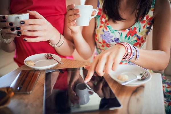 Dos chicas en una cafetería, sonriendo, cotilleando, bebiendo café — Foto de Stock
