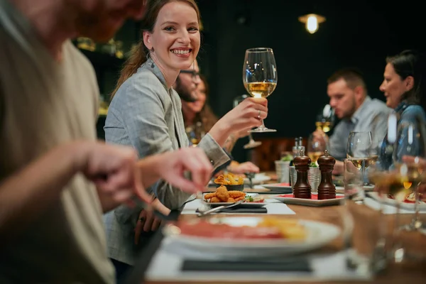 Okouzlující Usmívající Žena Sedí Restauraci Přáteli Večeři Drží Sklenici Bílého — Stock fotografie