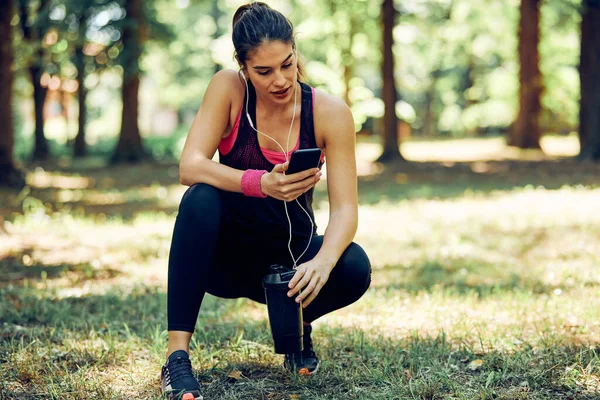 Atractivo Ajuste Corredor Femenino Agacharse Usando Teléfono Tomar Descanso Después — Foto de Stock