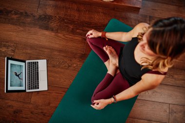 Orta yaşlı Yogi kadın evde yoga yapıyor..