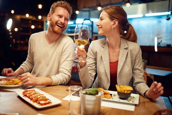 부부가 식당에 저녁을 수다를 남자가 여자에게 이야기하는 여자가 자기의 백포도주를 — 스톡 사진
