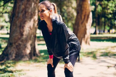 Sporcu bir kadın el ele tutuşup doğada koşmaya ara veriyor..