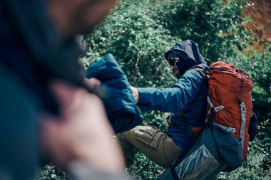 Tepeye tırmanan iki yürüyüşçü. Sırt çantaları var..