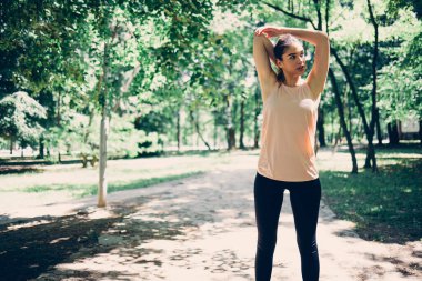 Formda koşucu doğada ısınma egzersizleri yapıyor..