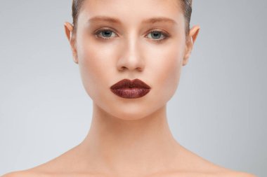 Stüdyoda dudaklarında kahverengi rujla poz veren güzel bir sarışın..