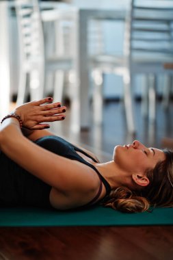 Orta yaşlı Yogi kadın evde yoga yapıyor.