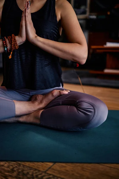 A woman sitting in a lotus yoga pose and meditating.