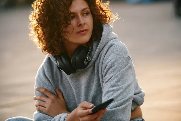 Giovane Donna Con Capelli Ricci Seduta Sulla Strada Agghiacciante — Foto Stock