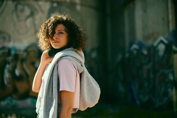 Young Woman Curly Hair Standing Street Putting Listening Music — Foto de Stock