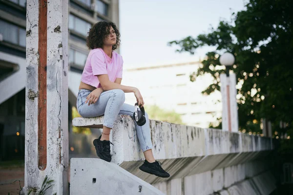 Una Joven Atractiva Mujer Con Pelo Rizado Sentado Aire Libre — Foto de Stock