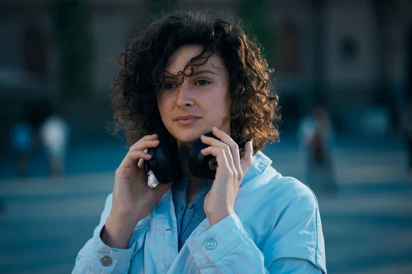 Una Mujer Joven Pie Una Calle Con Auriculares Alrededor Del — Foto de Stock