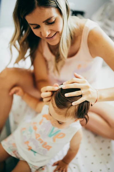 Niña Sentada Cama Con Madre Arreglándose Pelo — Foto de Stock