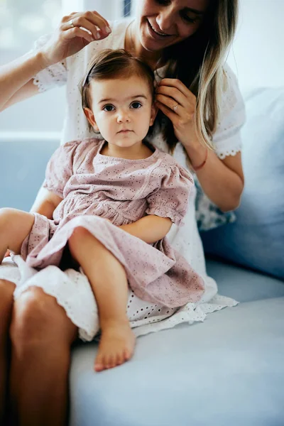 Young Mother Making Hairstyle Her Baby Girl While Holding Her — Stock Photo, Image