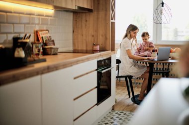 Annesinin evinde kalıp mutfakta oturacak ve küçük kızı ona yardım ederken işini bitirecek..