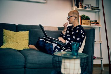 Çekici bir kıdemli çalışan evde oturuyor ve iş arkadaşlarıyla görüntülü görüşme yapıyor..