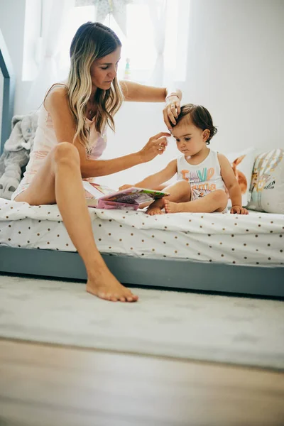 Joven Madre Haciendo Peinado Para Bebé Mientras Sostiene Regazo — Foto de Stock