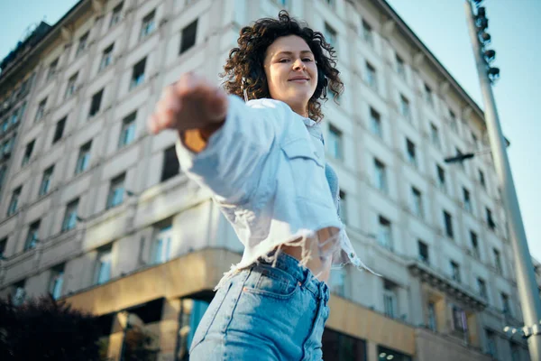 Uma Jovem Alegre Com Cabelo Encaracolado Com Fones Ouvido Está — Fotografia de Stock