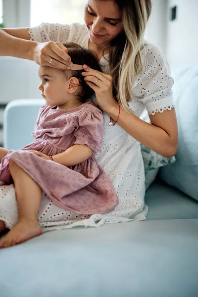 Jovem Mãe Fazendo Penteado Para Sua Menina Enquanto Segurando Seu — Fotografia de Stock