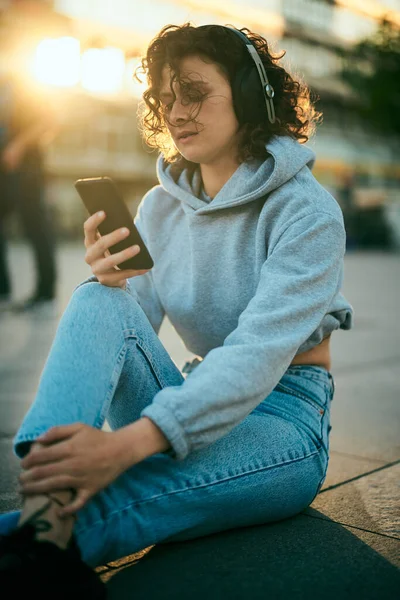 Una Giovane Donna Felpa Seduta Strada Ascolta Musica Telefono — Foto Stock