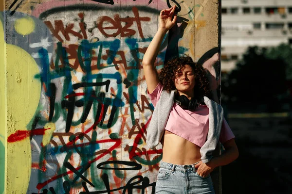 Uma Jovem Com Cabelo Encaracolado Está Contra Parede Desfrutando Dia — Fotografia de Stock