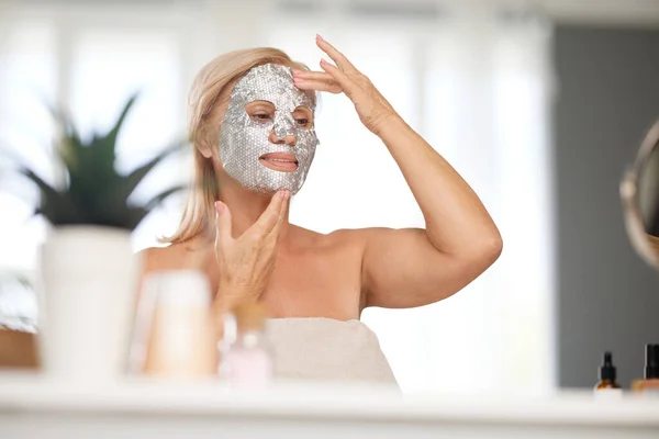 Senior Woman Putting Beauty Face Mask Her Face While Sitting — Stock Photo, Image