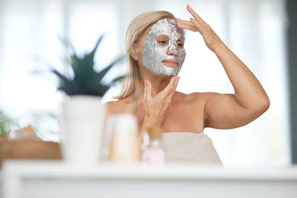 Senior Woman Putting Beauty Face Mask Her Face While Sitting — Stock Photo, Image