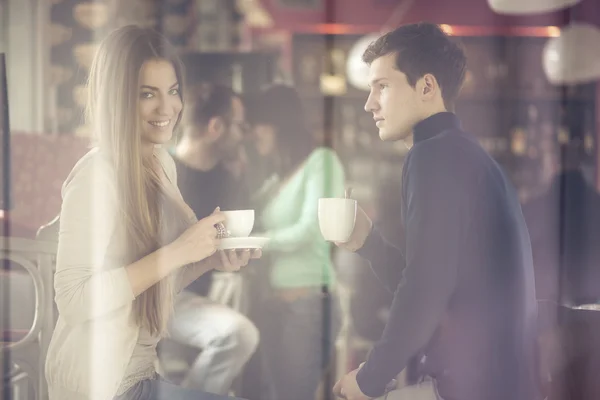 Two couples shot through window enjoying coffee — Stock Photo, Image