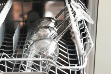 Bulaşık makinesindeki çiğ şarap kadehlerinin fotoğrafını çek. Temizlik kavramı. Bulaşık makinesinde şarap bardaklarını temizlemek için seçmeli odak noktası.