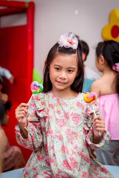 귀여운 아이가 사탕을 소녀가 형형색색의 무지개 롤리팝을 즐기는 — 스톡 사진