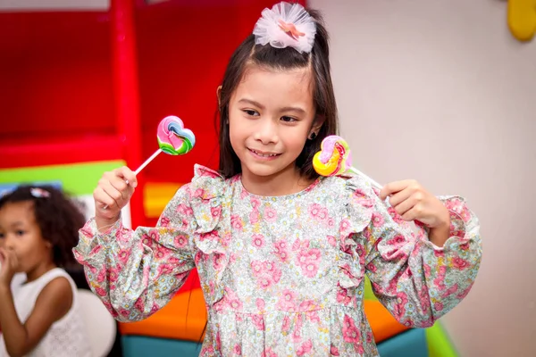 귀여운 아이가 사탕을 소녀가 형형색색의 무지개 롤리팝을 즐기는 — 스톡 사진