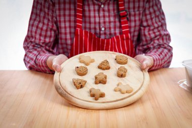 Fırıncı adam elinde Noel kurabiyesi tepsisi, ev yapımı kurabiyeler pişirdikten sonra zencefilli ekmek, fırın hazırlamak, evde pişirme ve pişirme süreci