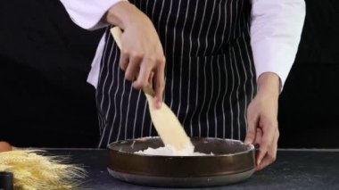 Fırıncı hamuru hazırlıyor, hamuru yoğurmadan önce sütü döküyor, ev yapımı fırın konsepti.