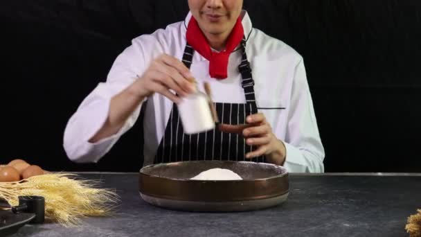 Pekař připravuje těsto na chleba, nalévá mléko do mouky před hnětením těsta, jídlo domácí pekařské koncepce