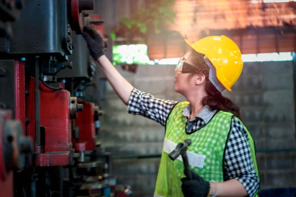 工业工程师女工头戴安全帽 戴着安全眼镜 在制造厂机械维修和操作 年轻漂亮的女工在工厂工作 — 图库照片