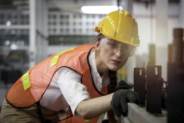 工业工程师女工戴着安全帽和安全眼镜 与制造厂的仪器一起工作 年轻漂亮的女工在工厂工作 — 图库照片