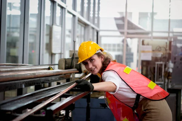 Industrial engineer worker wearing helmet and safe glasses, working with instrument at manufacturing plant factory, young beautiful woman working in industry