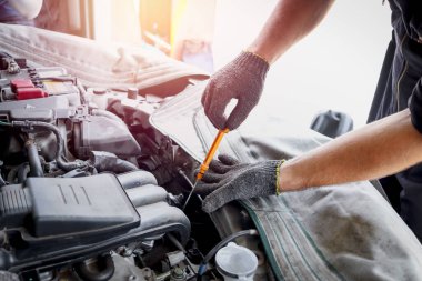 Auto mechanic hand working with engine in garage, car service technician repairing customer car at automobile service center, inspecting car suspension and engine system, vehicle repair service shop.