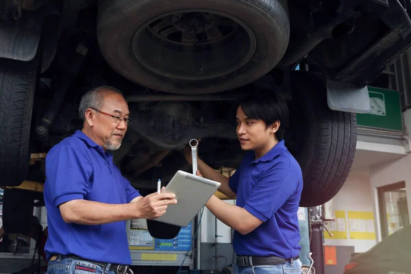 Two Mechanic Checking Wheel Inspecting Car Body Suspension System Garage —  Fotos de Stock