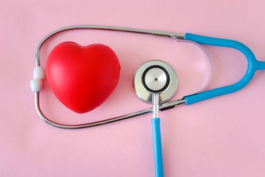 Tatlı pembe arka planda kırmızı kalp ve doktor steteskobu, Sevgililer Günü konsepti tıbbi ve sağlık hizmetleri için romantik aşk.