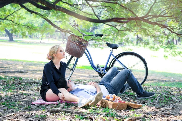 커플이 공원에서 피크닉에서 휴식을 취하고 남자는 친구의 무릎에 아름다운 연인은 — 스톡 사진