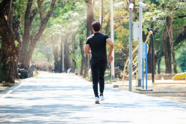 Genç koşucu sabah koşuyor, dışarıda egzersiz yapıyor, sporcu erkek koşucu bahçedeki parkta spor yapıyor.