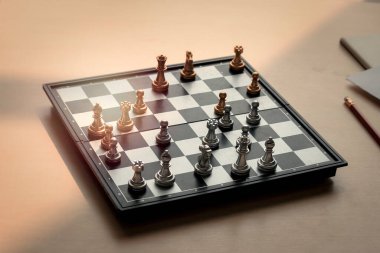 Satranç tahtasıyla tahta bir masanın üzerinde satranç figürleri oyun için hazır.